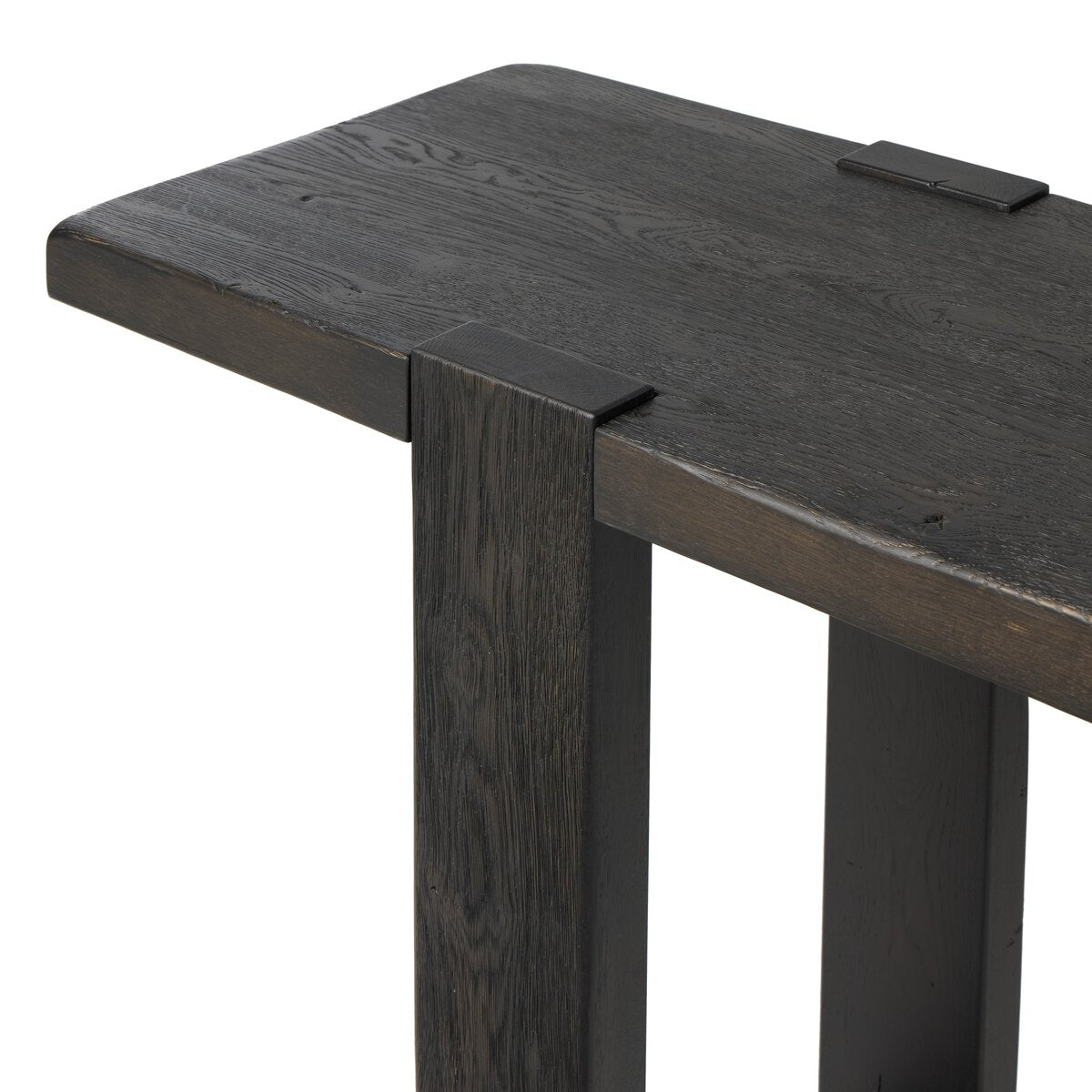 Four Hands Matei Console Table in smoked black solid oak with through-tenon joints, close-up detail of tenon joint, view 1