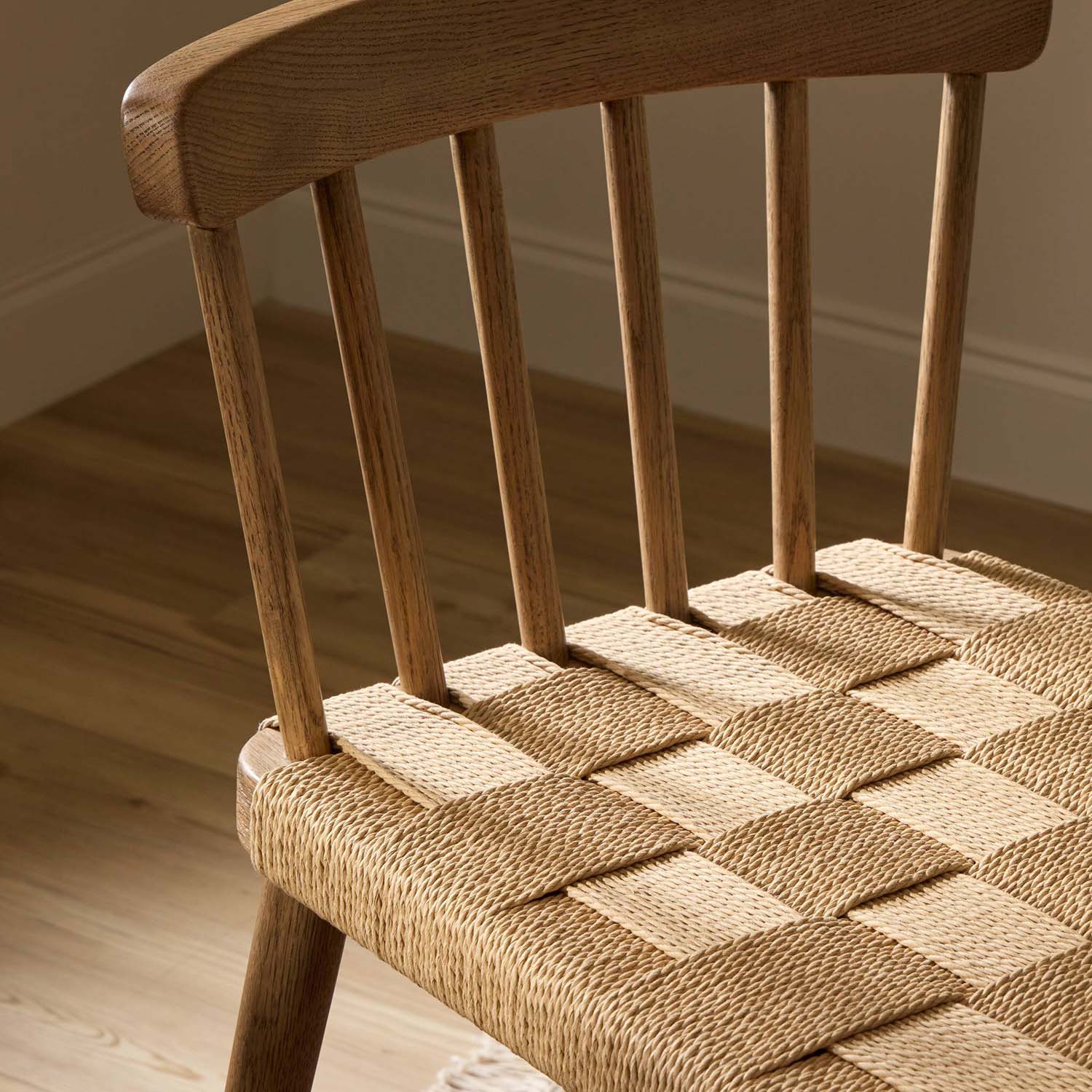 Four Hands Kershaw Counter Stool in smoked oak with rush woven seat, close-up detail of spindle back and rush seat, view 1