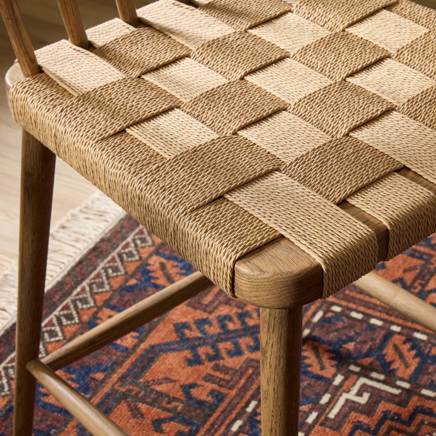 Four Hands Kershaw Counter Stool in smoked oak with rush woven seat, close-up detail of spindle back and rush seat, view 2