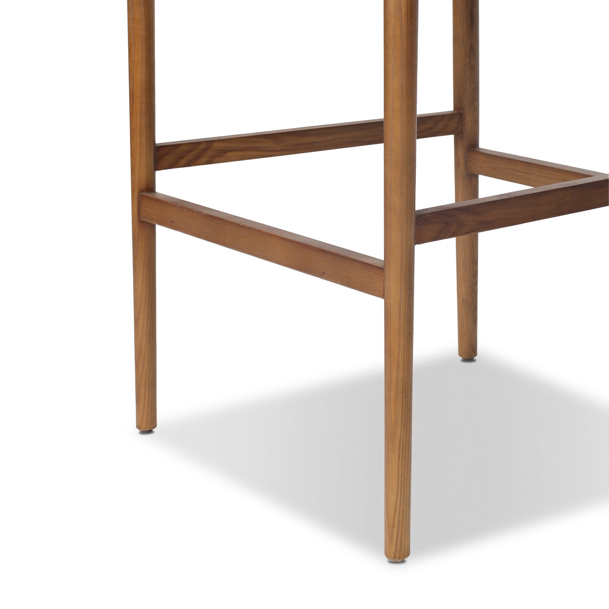 Four Hands Jazelle Dover Crescent Bar Stool Set of 2 on tan ash, close-up detail of ash leg