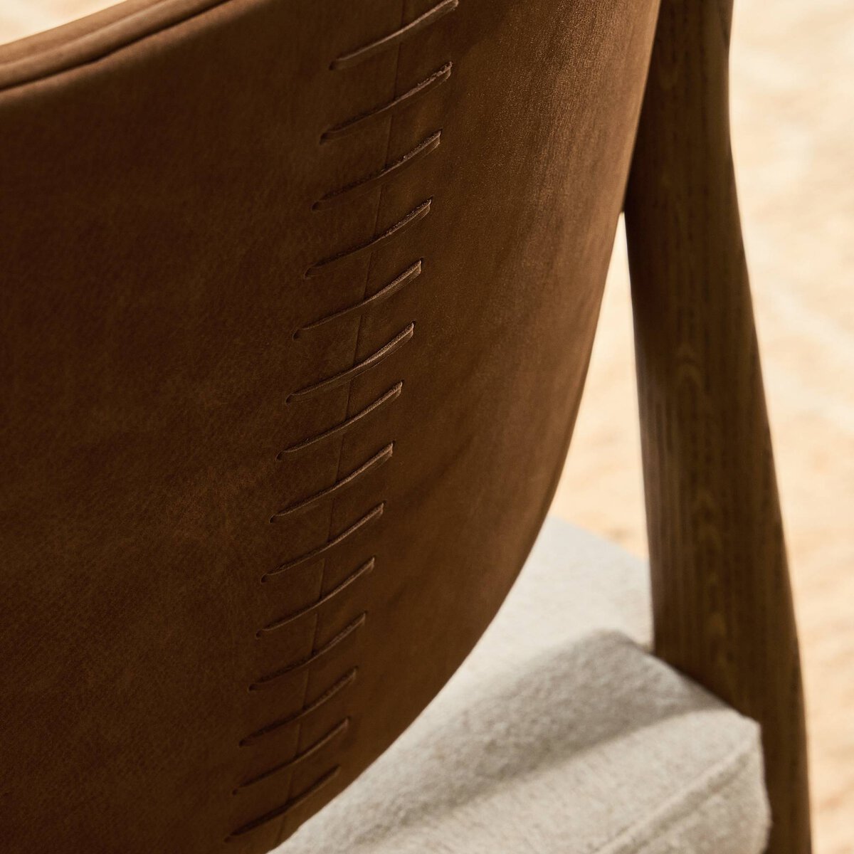 Four Hands Arlow Dining Chair in Nubuck Cognac leather back with natural linen seat on amber oak, close-up detail, view 2