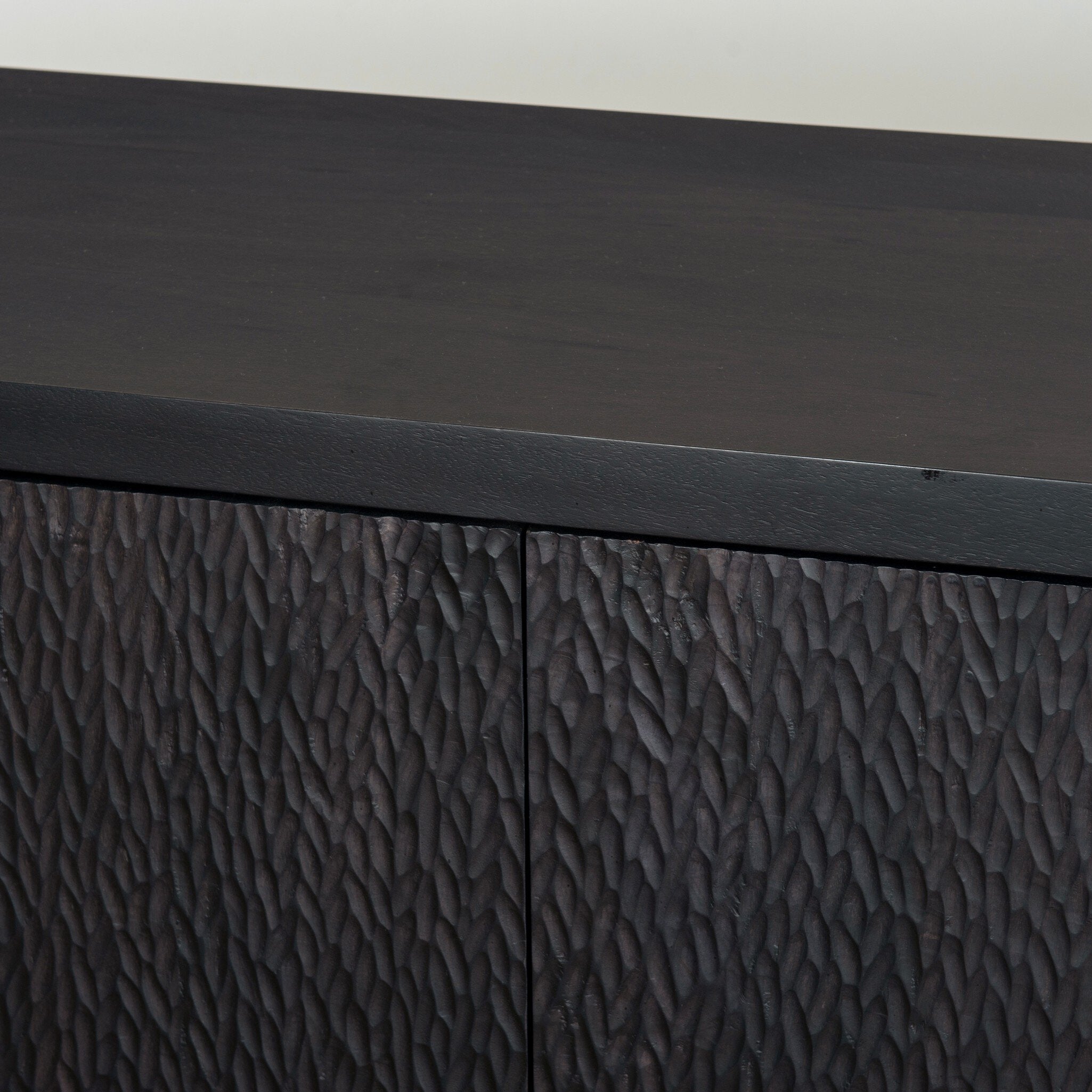 Four Hands Shevall Sideboard in carved black mango with cylinder legs, close-up detail of cylinder leg