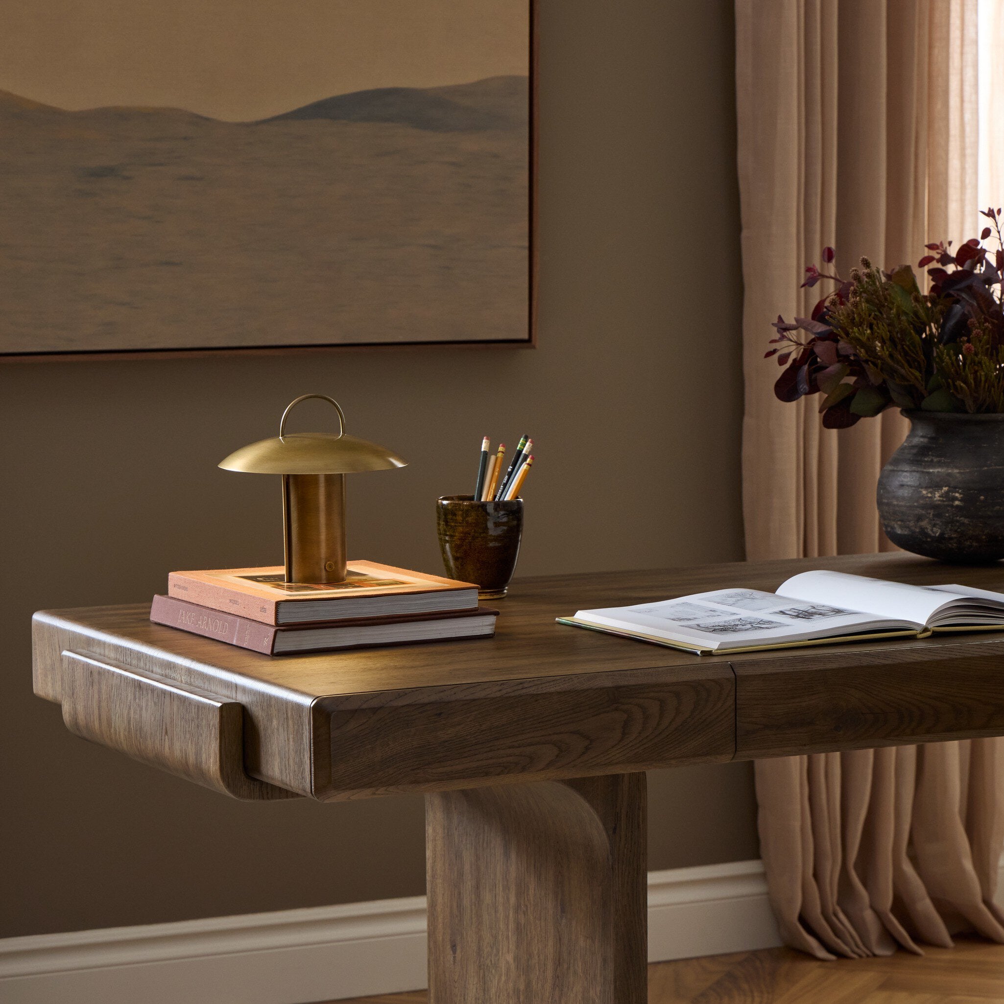 Four Hands Kivo Aged Antique Brass Iron Cordless Table Lamp in a styled room setting