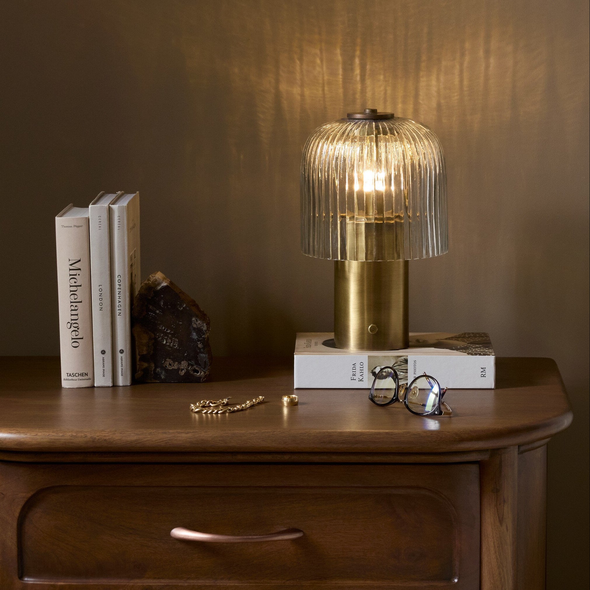 Four Hands Nomi Aged Antique Brass Iron Cordless Table Lamp styled in a room setting