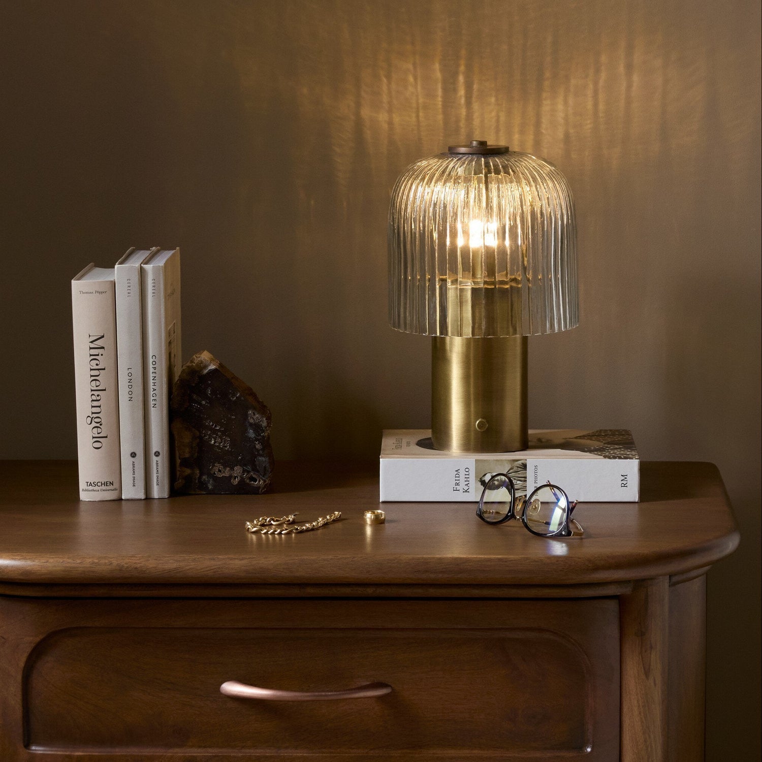 Four Hands Nomi Aged Antique Brass Iron Cordless Table Lamp styled in a room setting