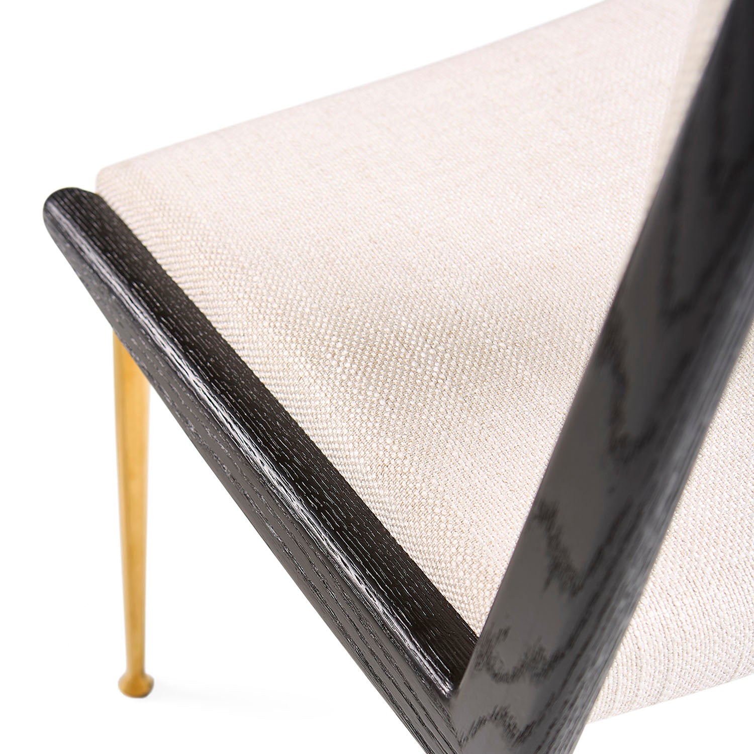 Jonathan Adler The St. Germain dining chair in blackened ash with brass and linen against a neutral backdrop