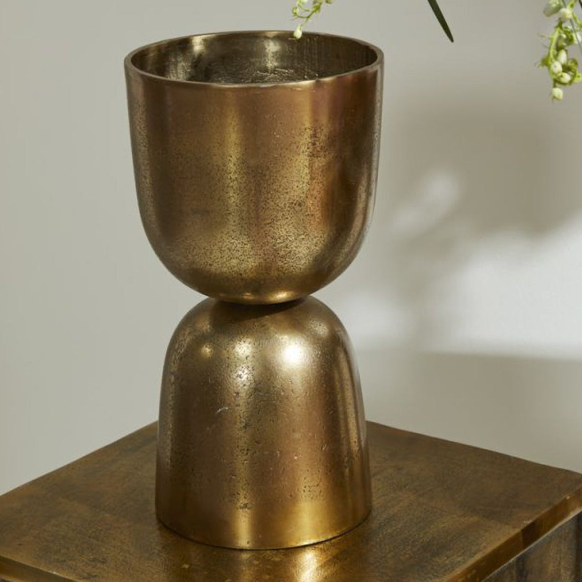 Lumos Footed Urn antique gold urn, holding a floral arrangement