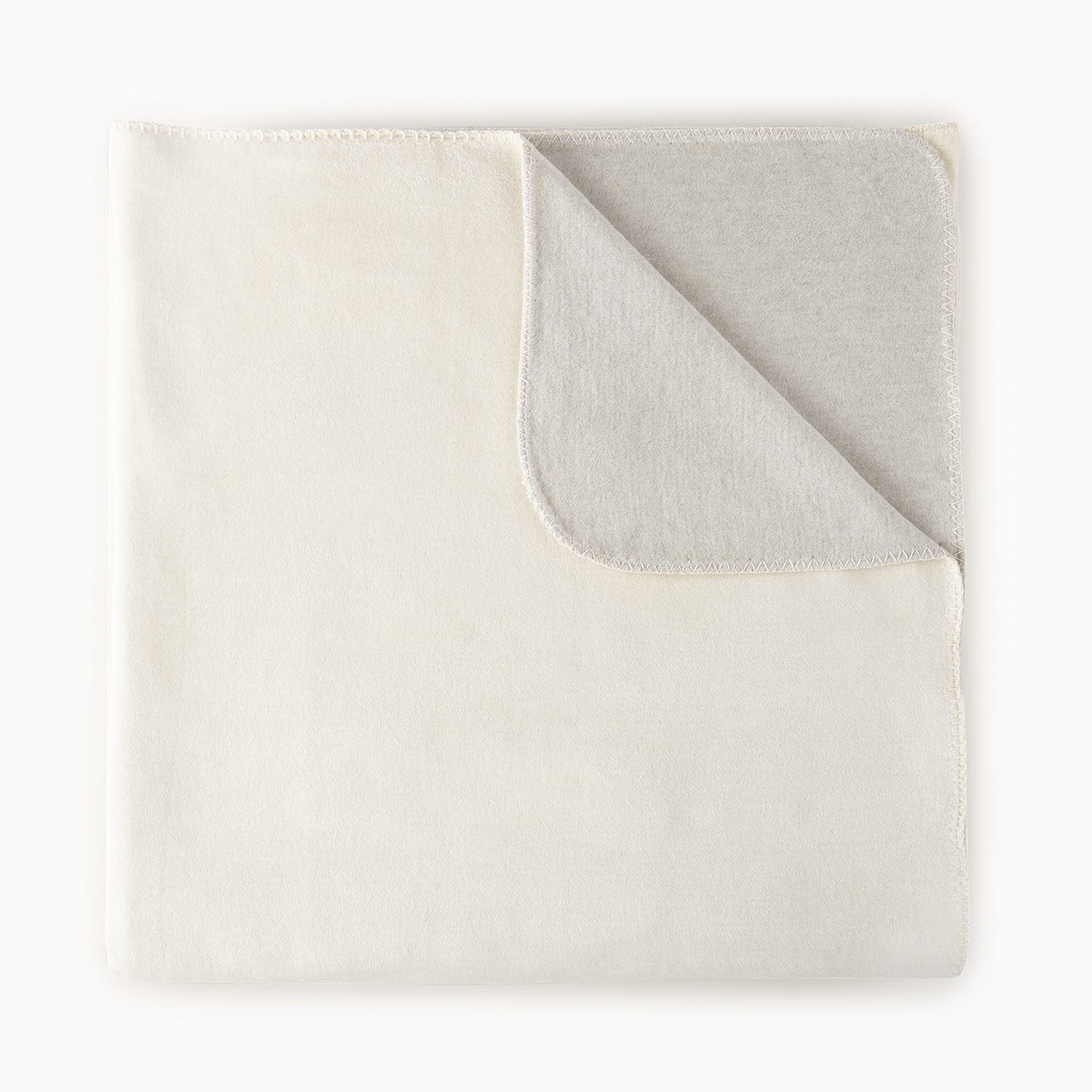 Peacock Alley Alta reversible cotton-blend throw blanket draped showing the reverse color