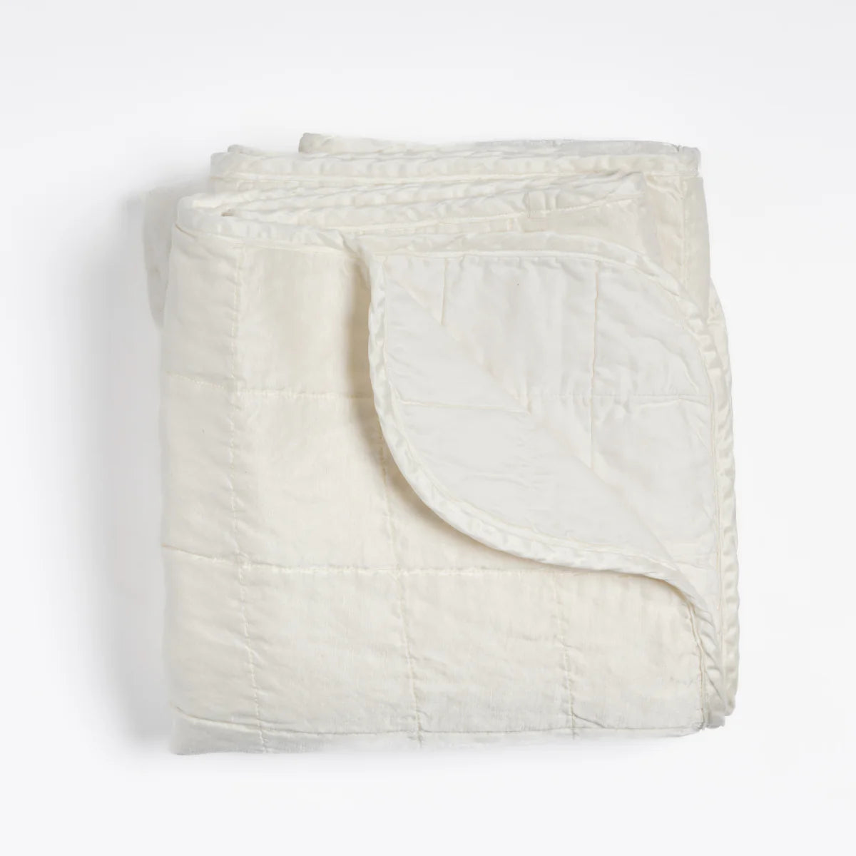 Bella Notte Sel Throw Blanket in quilted charmeuse, styled on a chaise for a relaxed look