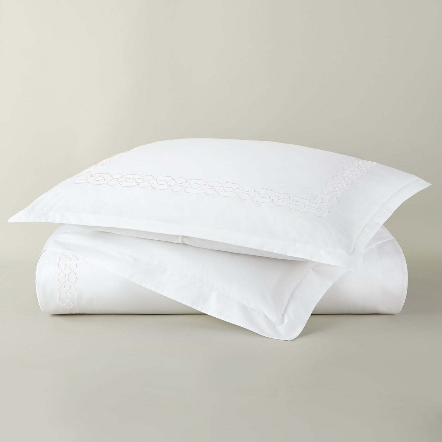 Peacock Alley Filigree embroidered cotton percale duvet set stack of neatly folded linens