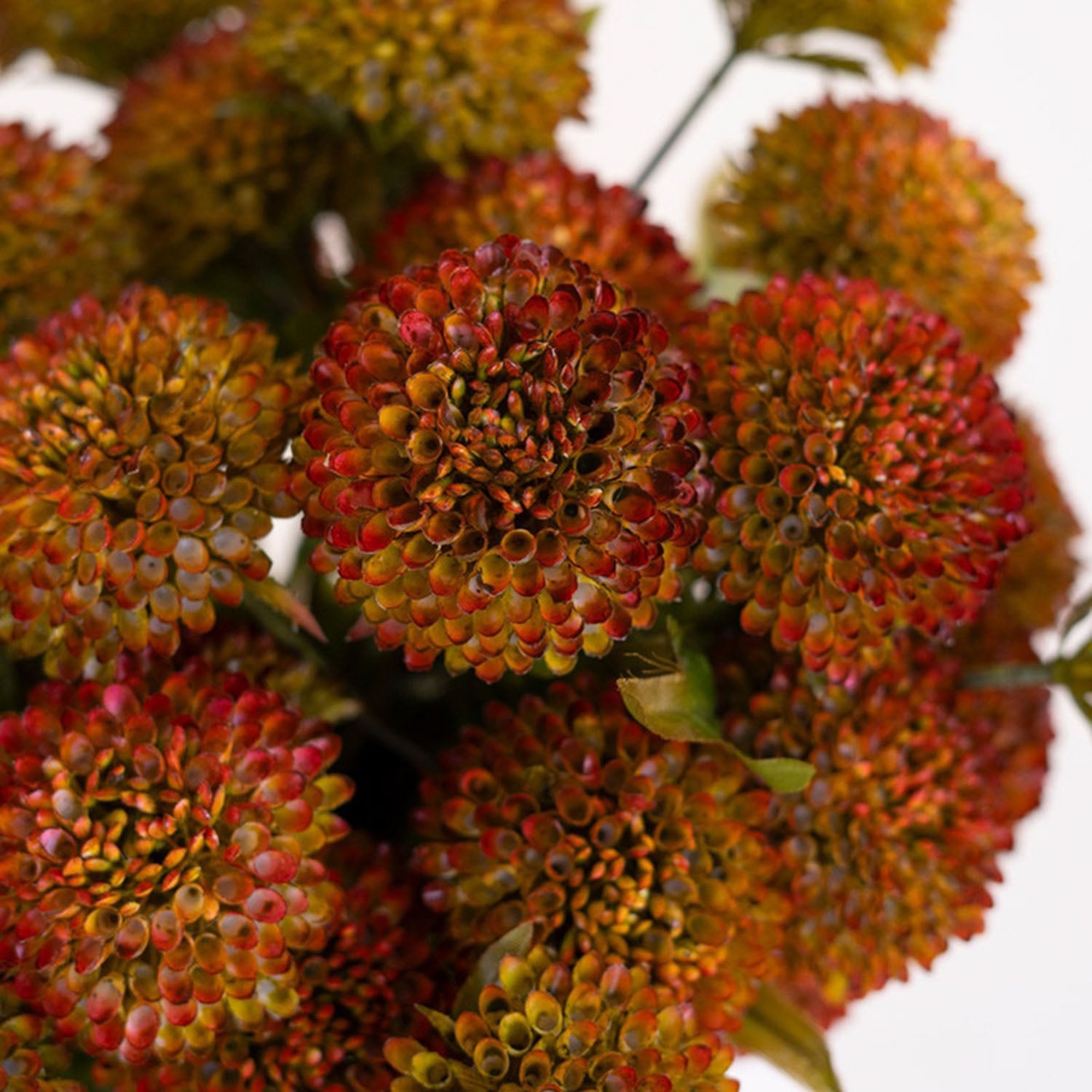Artificial dahlia stems arranged in a vase for styling