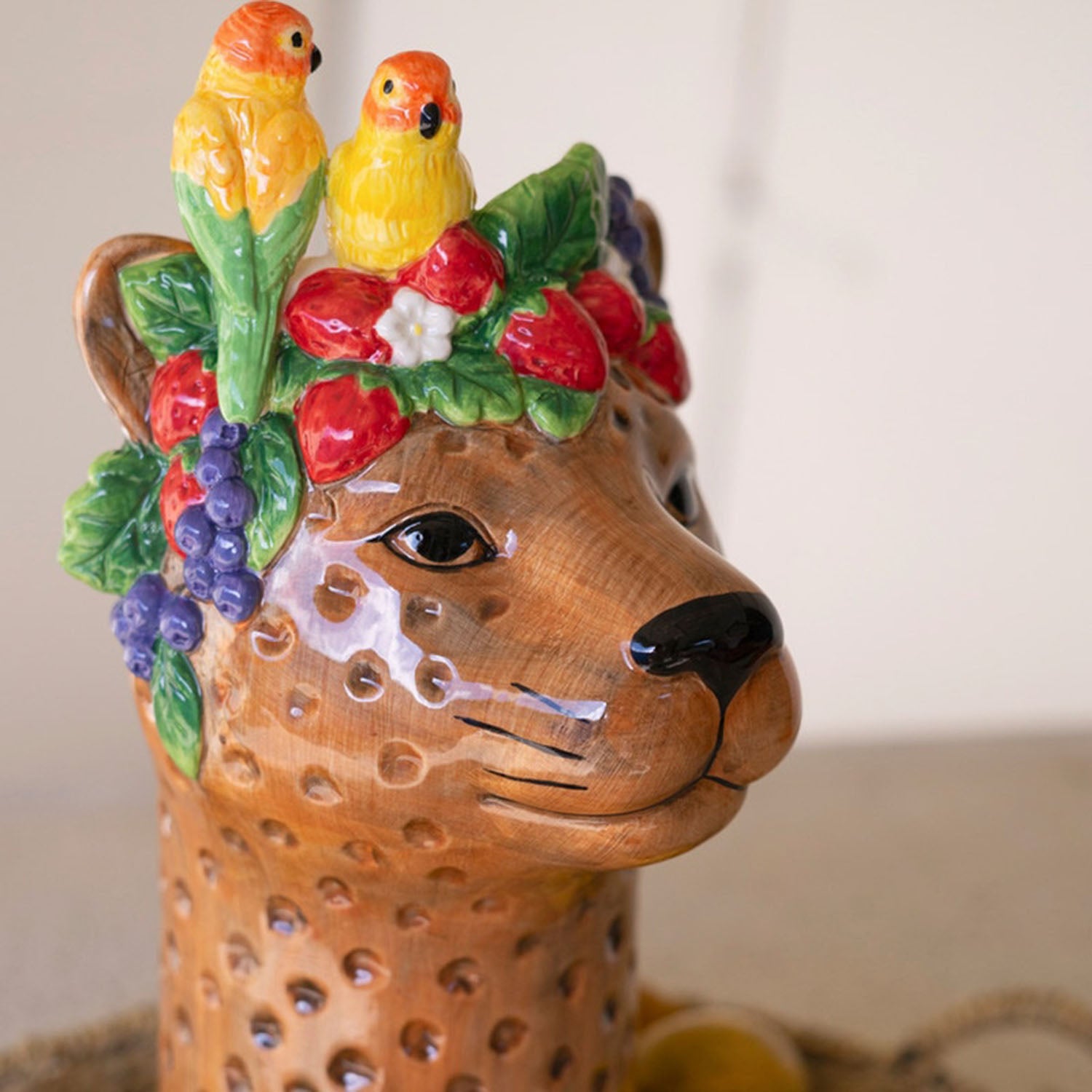 Close-up of the parrot and fruit detail on the ceramic vase