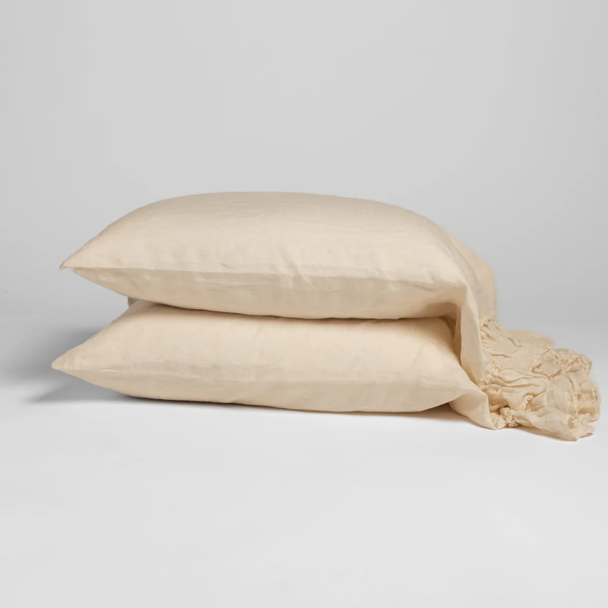 Bella Notte Linen Whisper Pillowcase in linen, shown paired on a bench seat