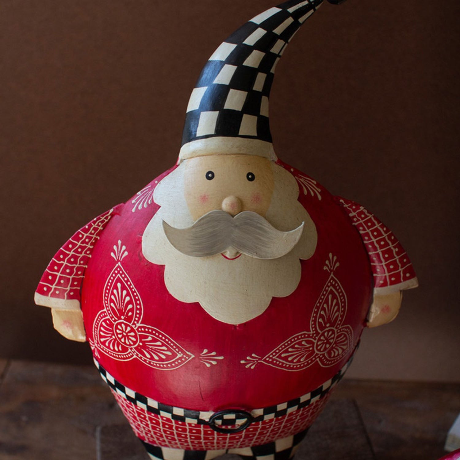 Close-up of the hand-painted checkerboard belt on the recycled metal Santa