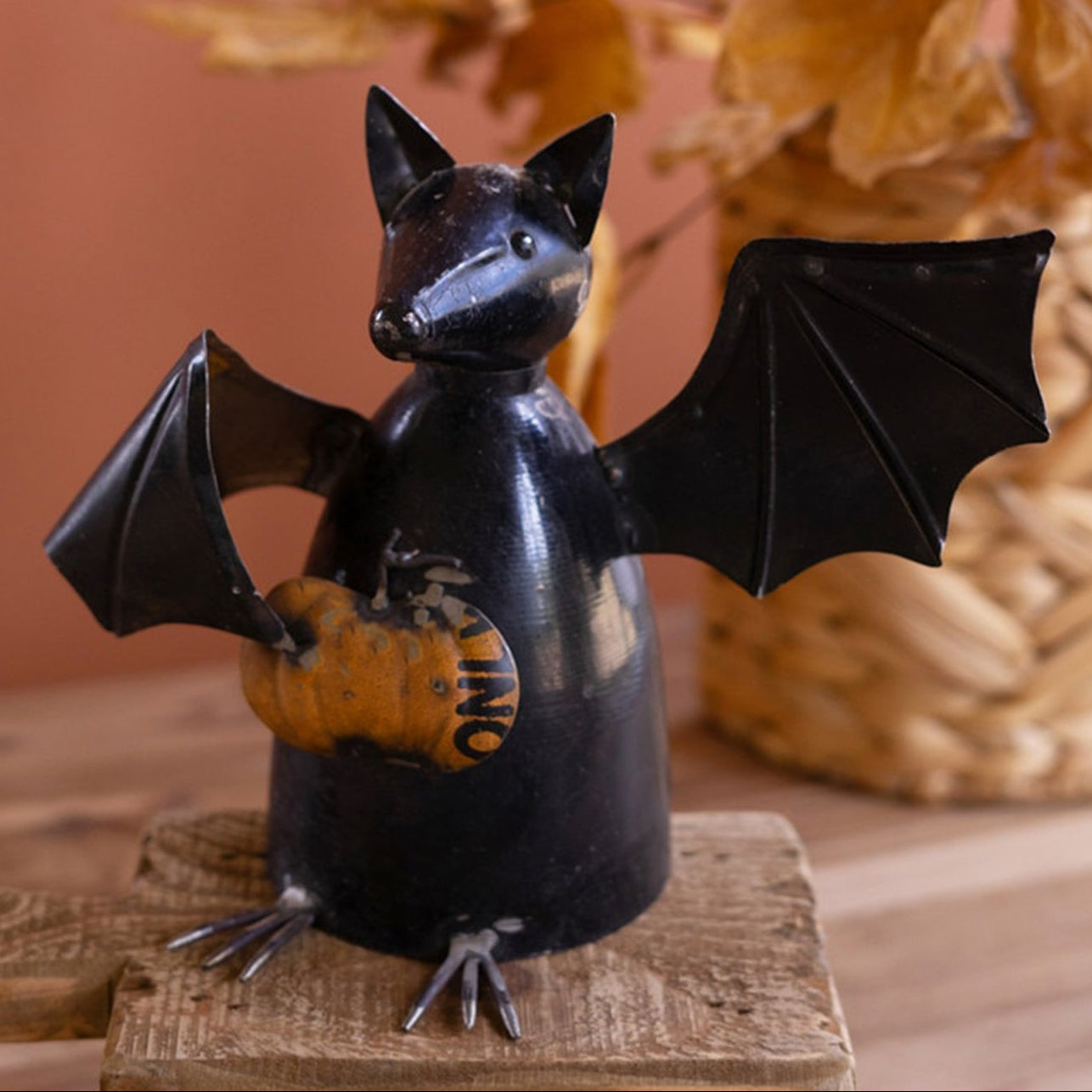 Recycled Metal Bat Holding a Pumpkin