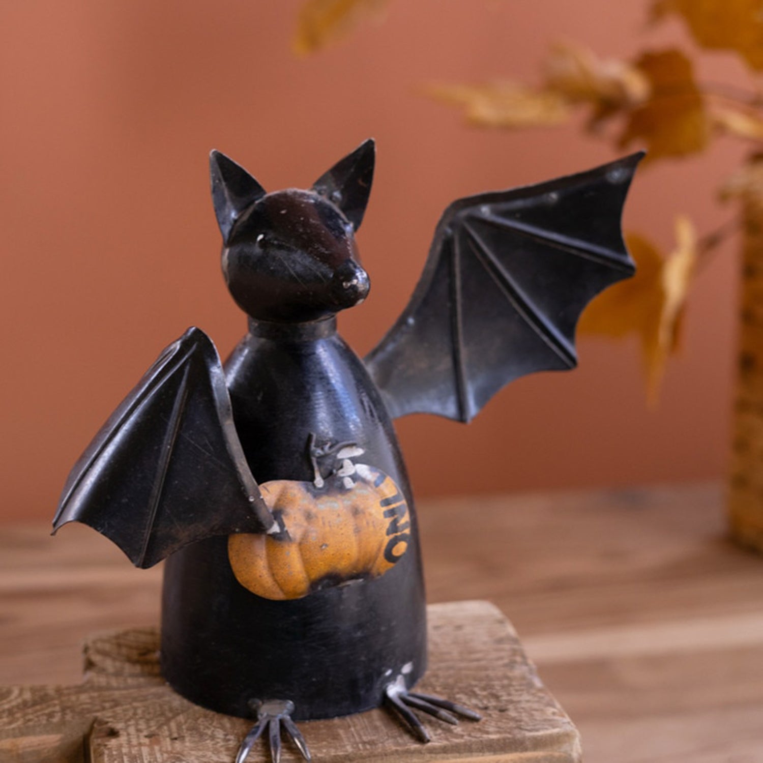 Recycled Metal Bat Holding a Pumpkin