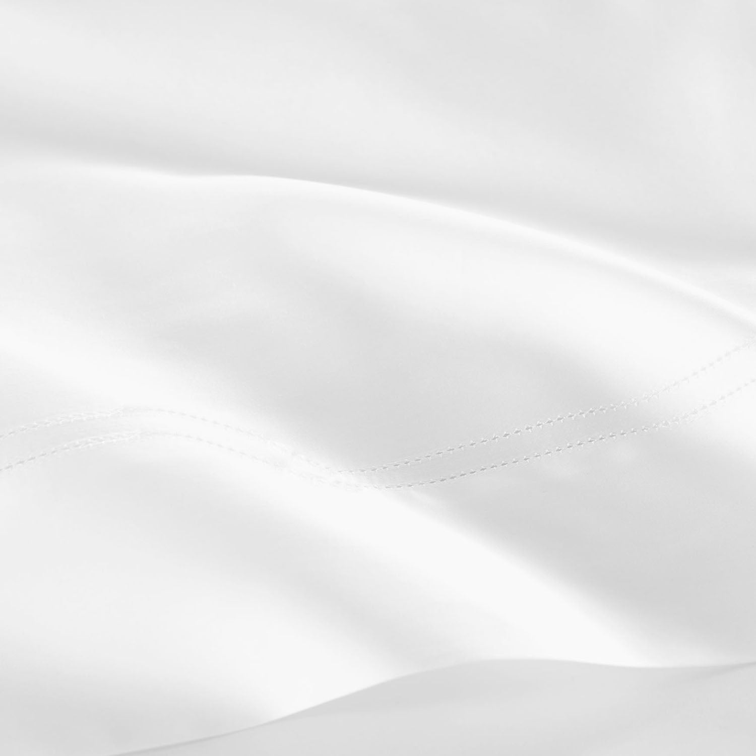 Peacock Alley Virtuoso Sateen Flat Sheet 600 thread count cotton sateen flat sheet, soft-focus lifestyle view on the bed