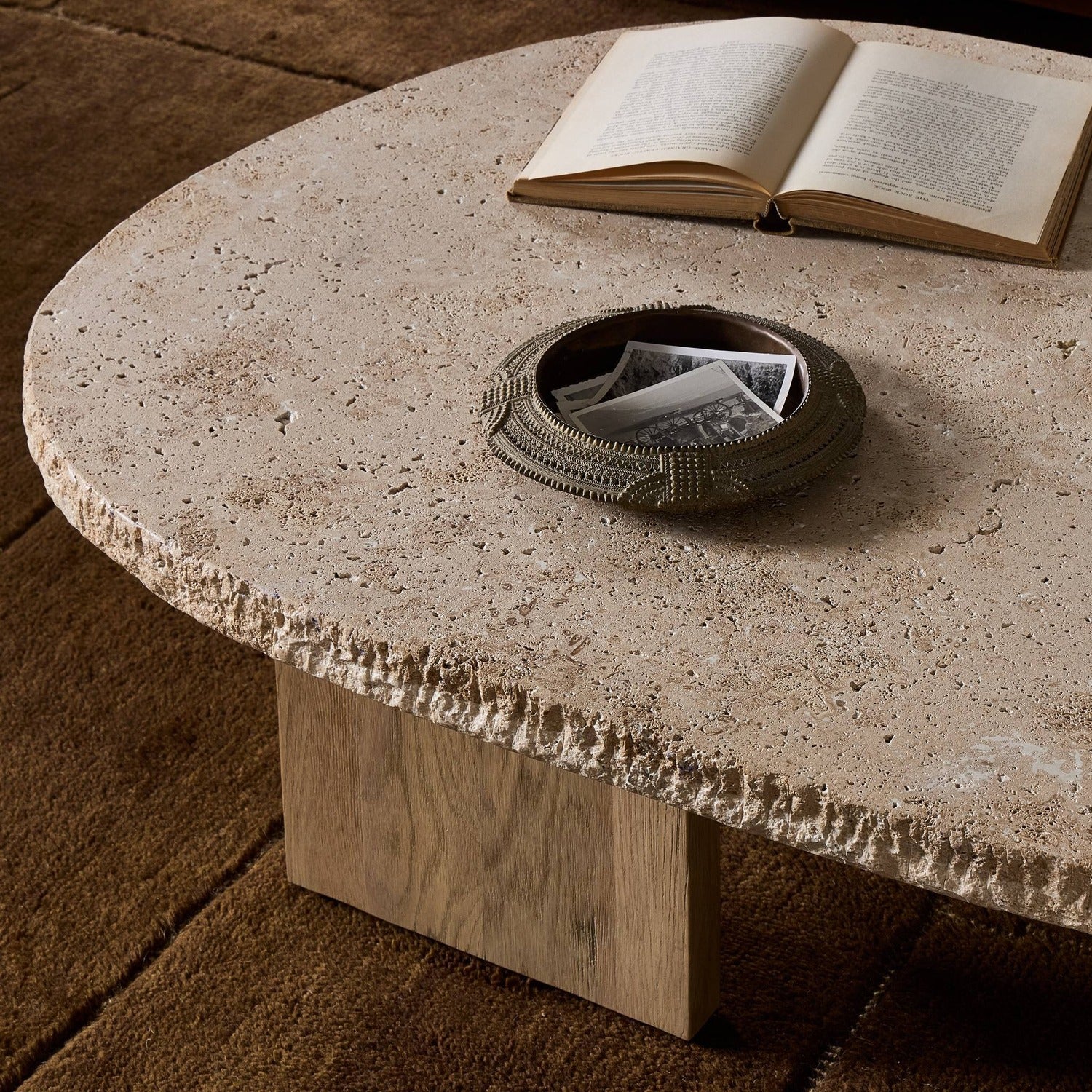 Four Hands Telma Chiseled Beige Lavastone Coffee Table with washed oak paddle legs, alternate styled view