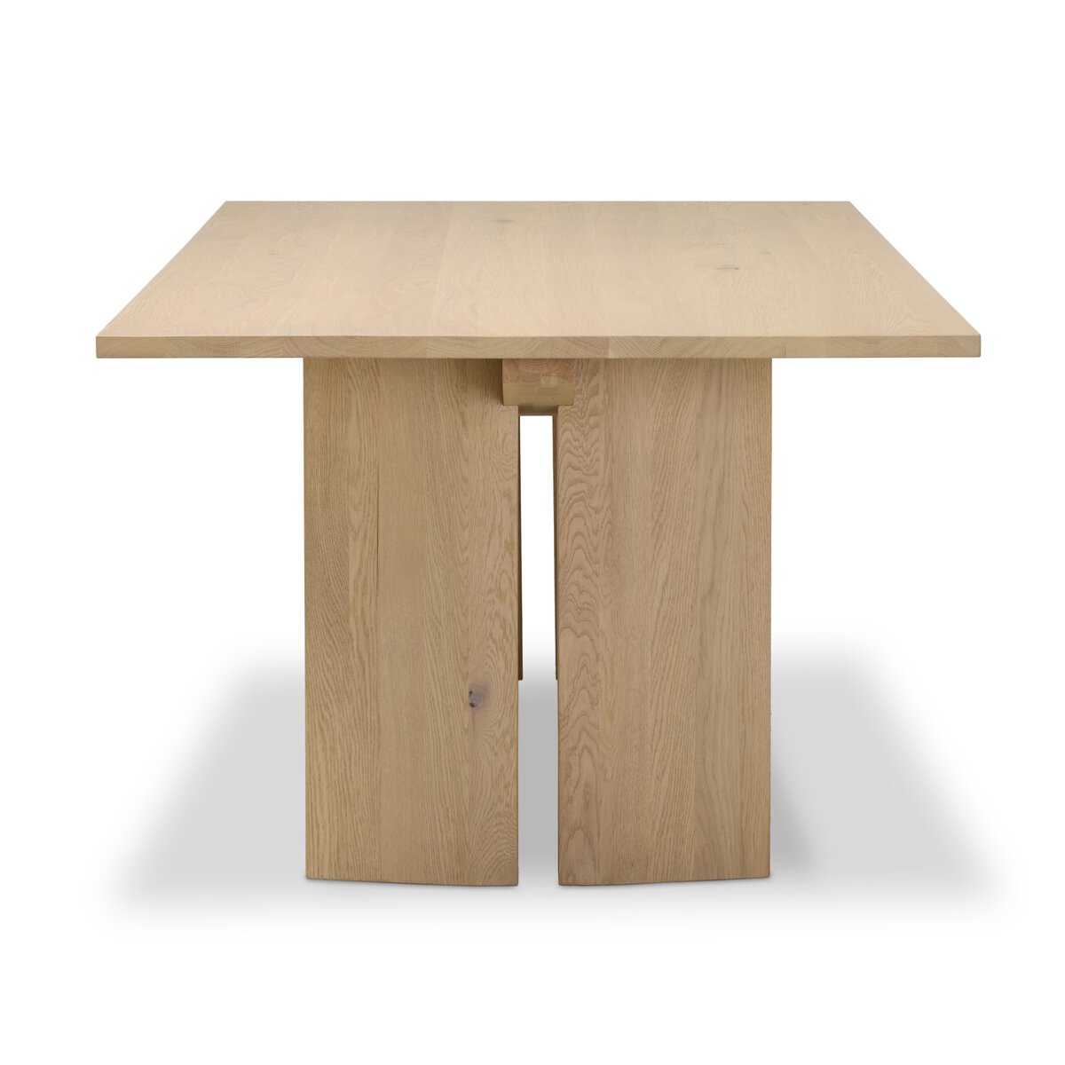 Four Hands Emerald Dining Table in bleached Romanian oak with splice leg detail, side profile view