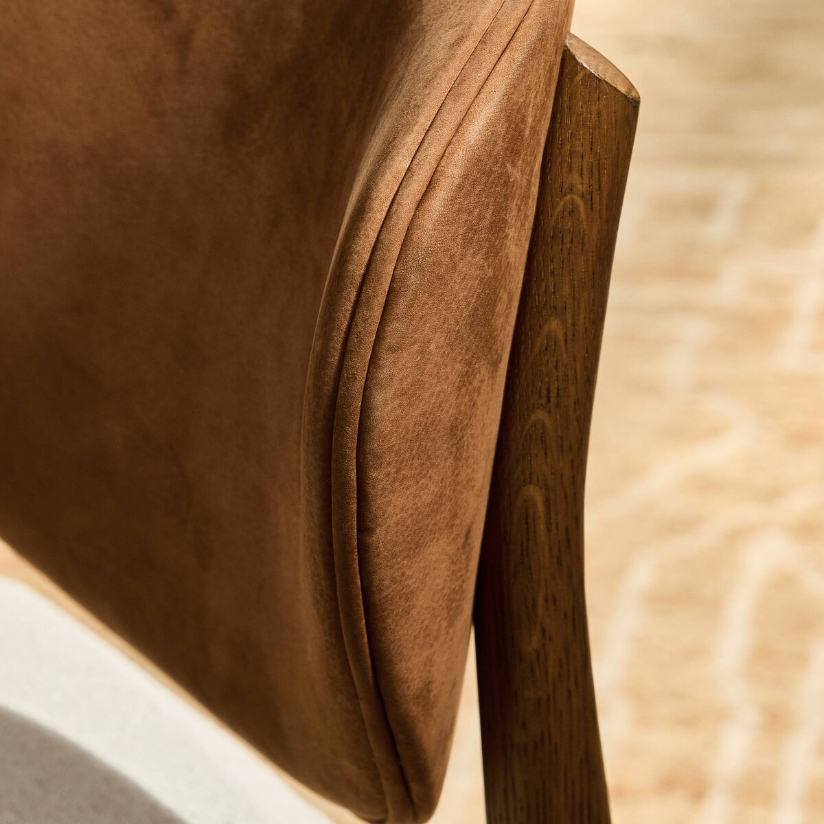 Four Hands Arlow Dining Chair in Nubuck Cognac leather back with natural linen seat on amber oak, close-up detail, view 1
