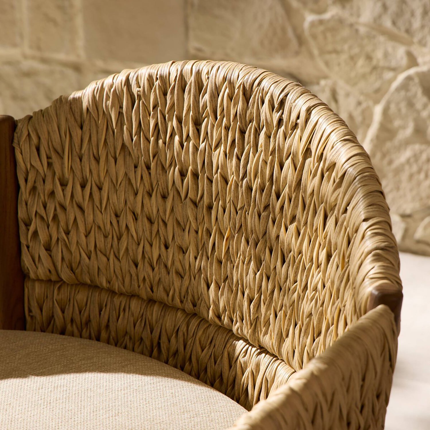 Four Hands Atwood Outdoor Chair in teak with coastal weave and beige cushion, close-up detail, view 6