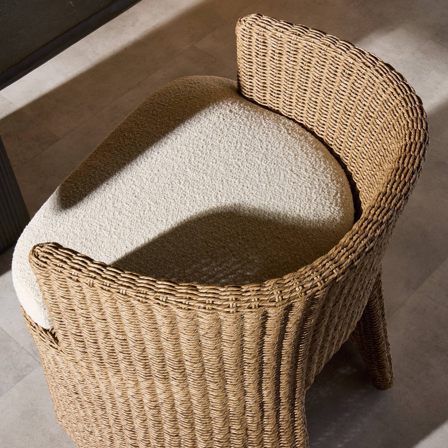 Four Hands Thora Vada Cream Outdoor Dining Chair in faux dark hyacinth with boucle cushion, alternate styled view, view 1