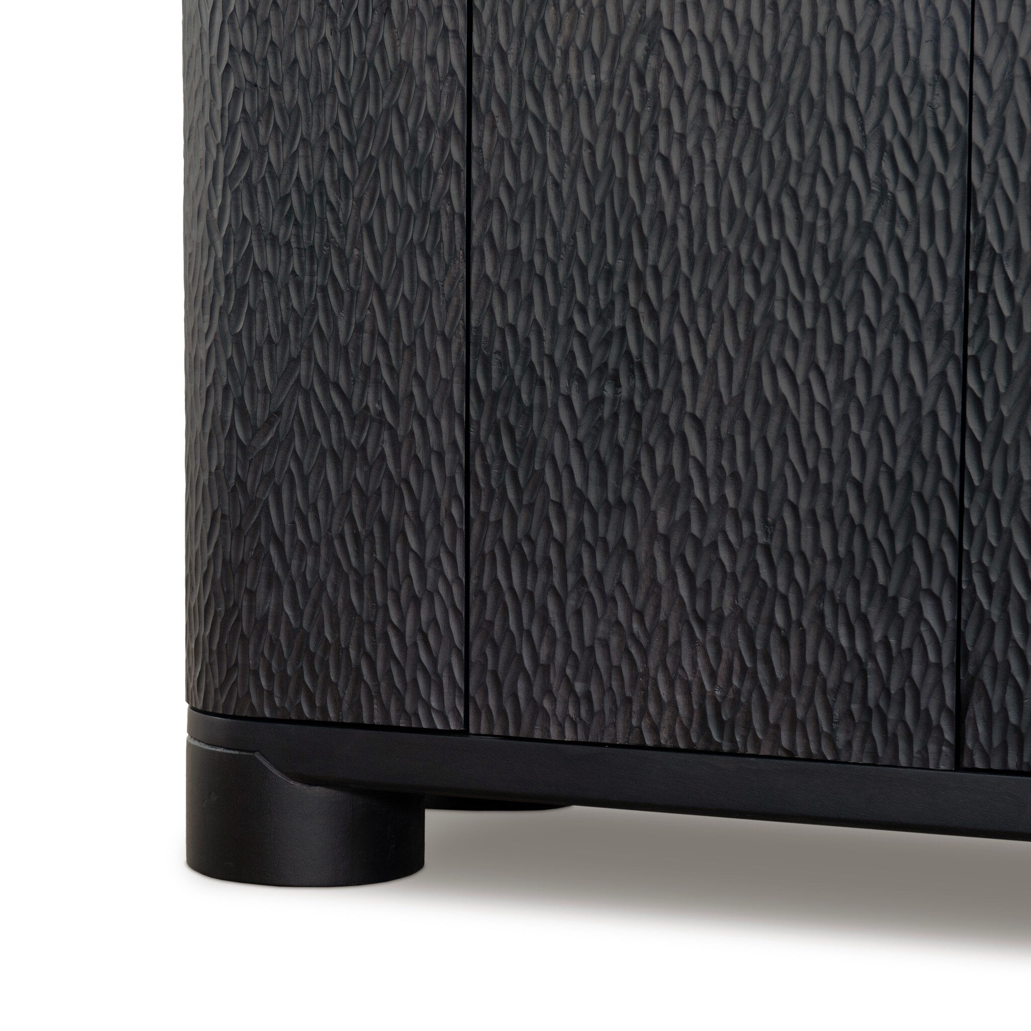 Four Hands Shevall Sideboard in carved black mango with cylinder legs, close-up detail of carved door front, view 4