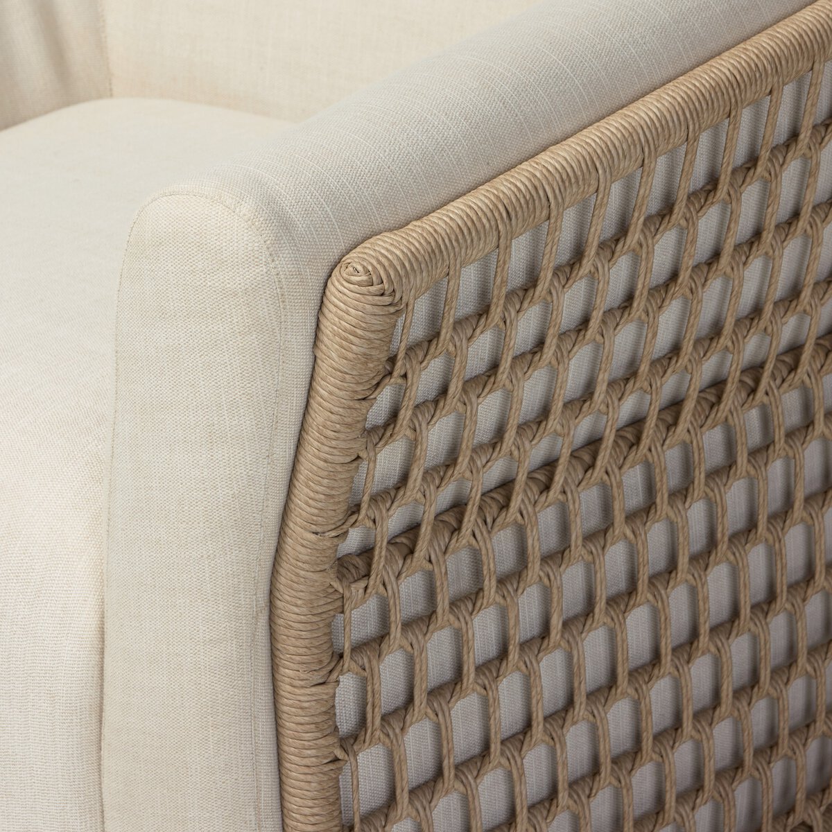 Four Hands Emilian Outdoor Swivel Chair in vintage white woven with cream cushion, close-up detail of weave, view 3