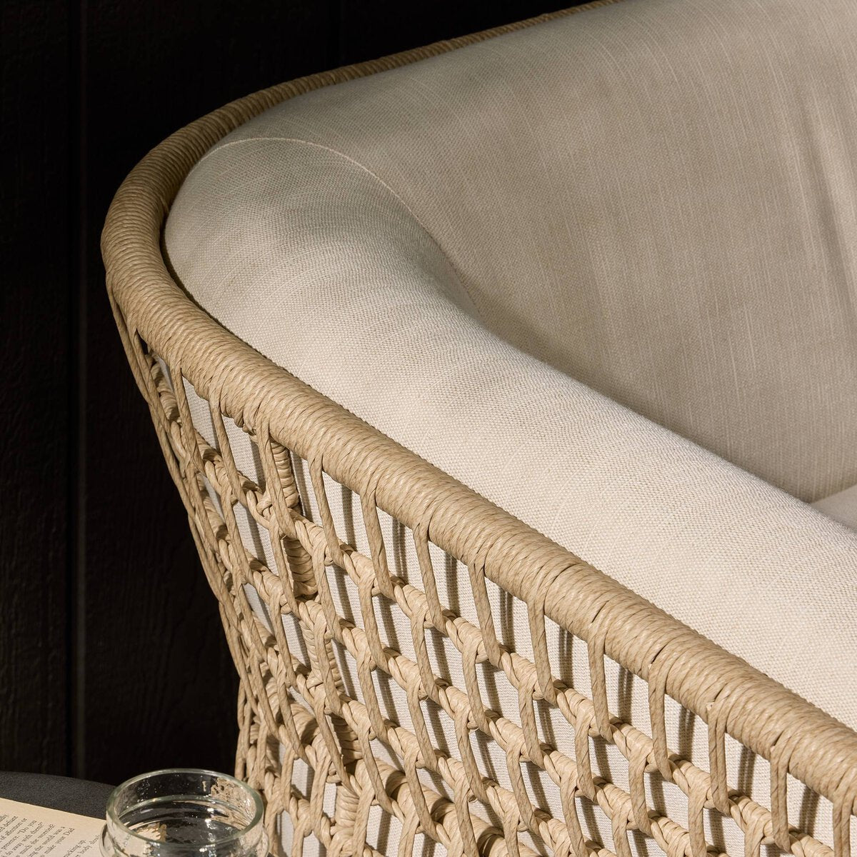 Four Hands Emilian Outdoor Swivel Chair in vintage white woven with cream cushion, close-up detail of weave, view 1