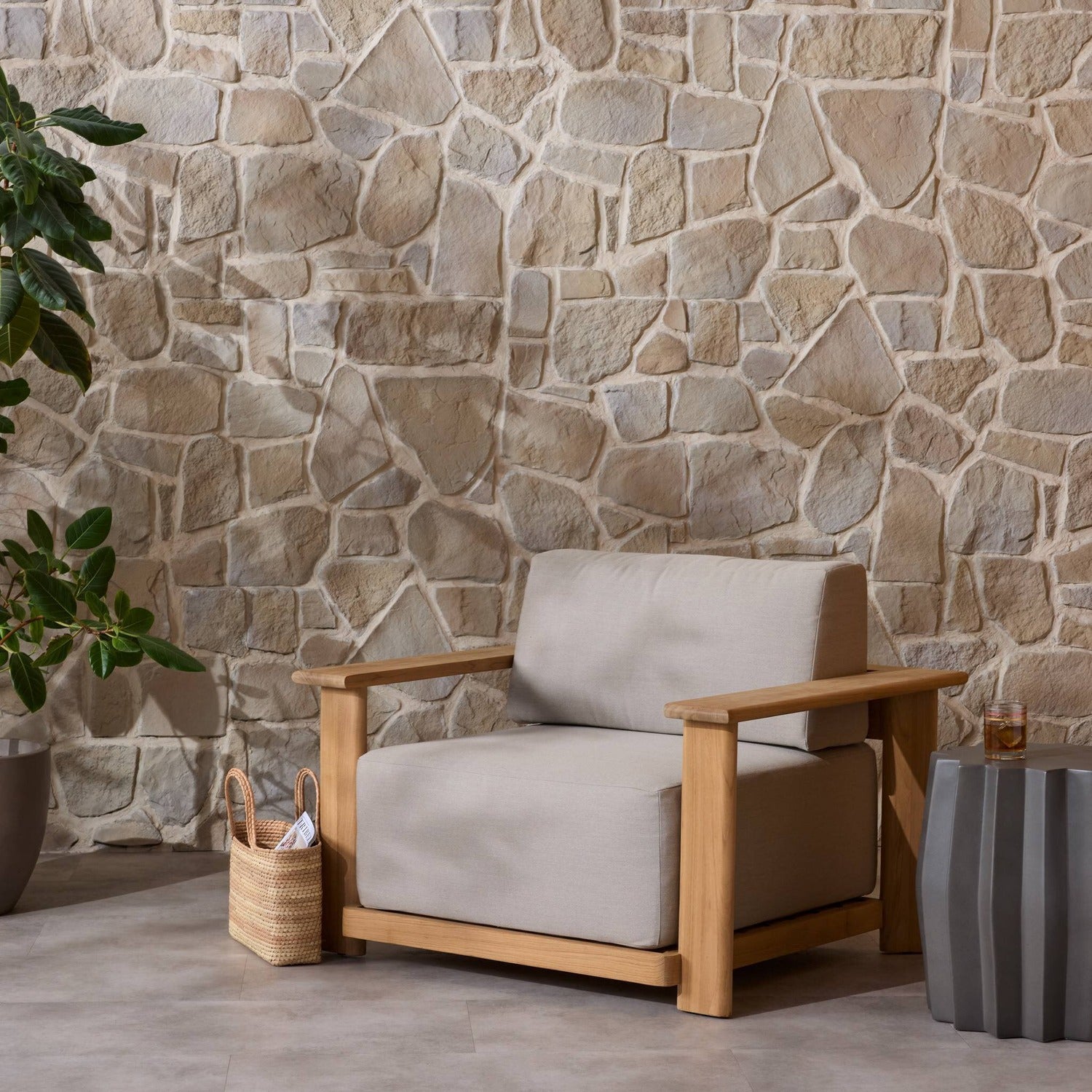 Four Hands Sterling Ibiza Mole Outdoor Chair in golden teak with mocha acrylic cushions, close-up styled view