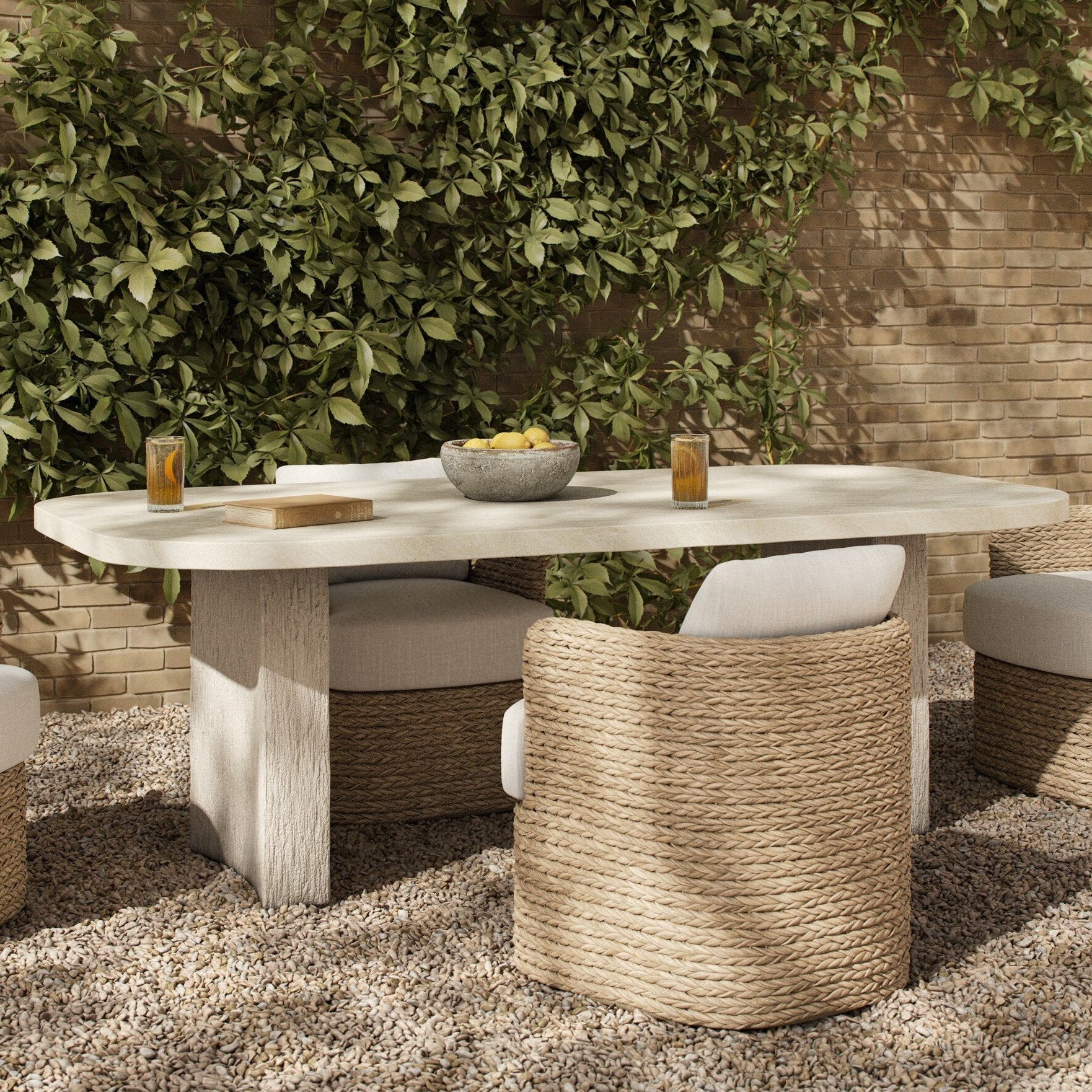 Four Hands Alessandro Smooth Quarried Cream Concrete Outdoor Dining Table styled in a room setting