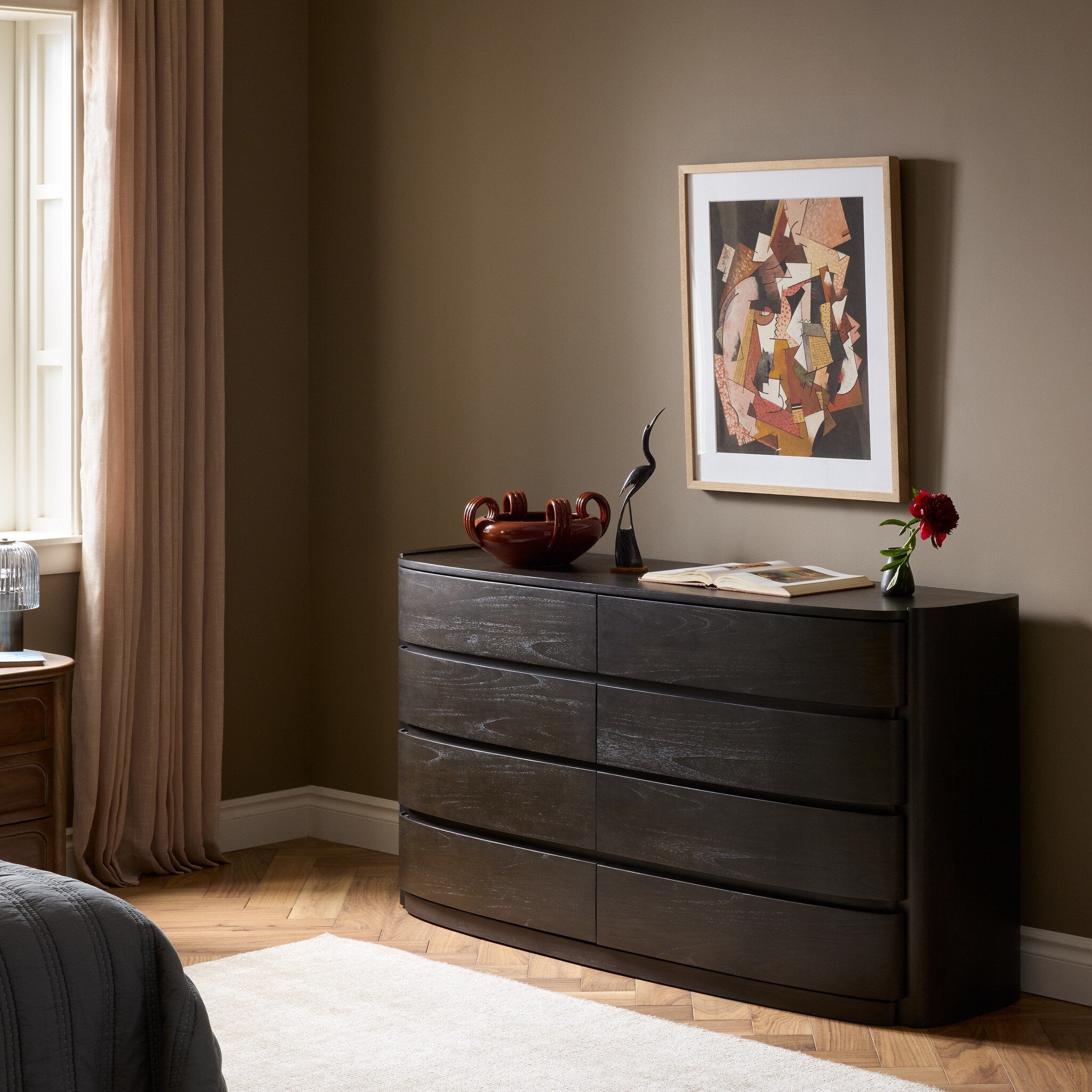 Four Hands Greer Smoked Black Sungkai 8 Drawer Dresser styled in a room setting