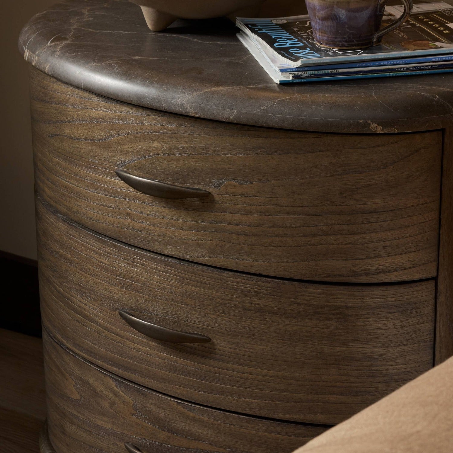 Four Hands Tovae Honed Coffee Marble Nightstand on saddle brown sungkai, alternate styled view