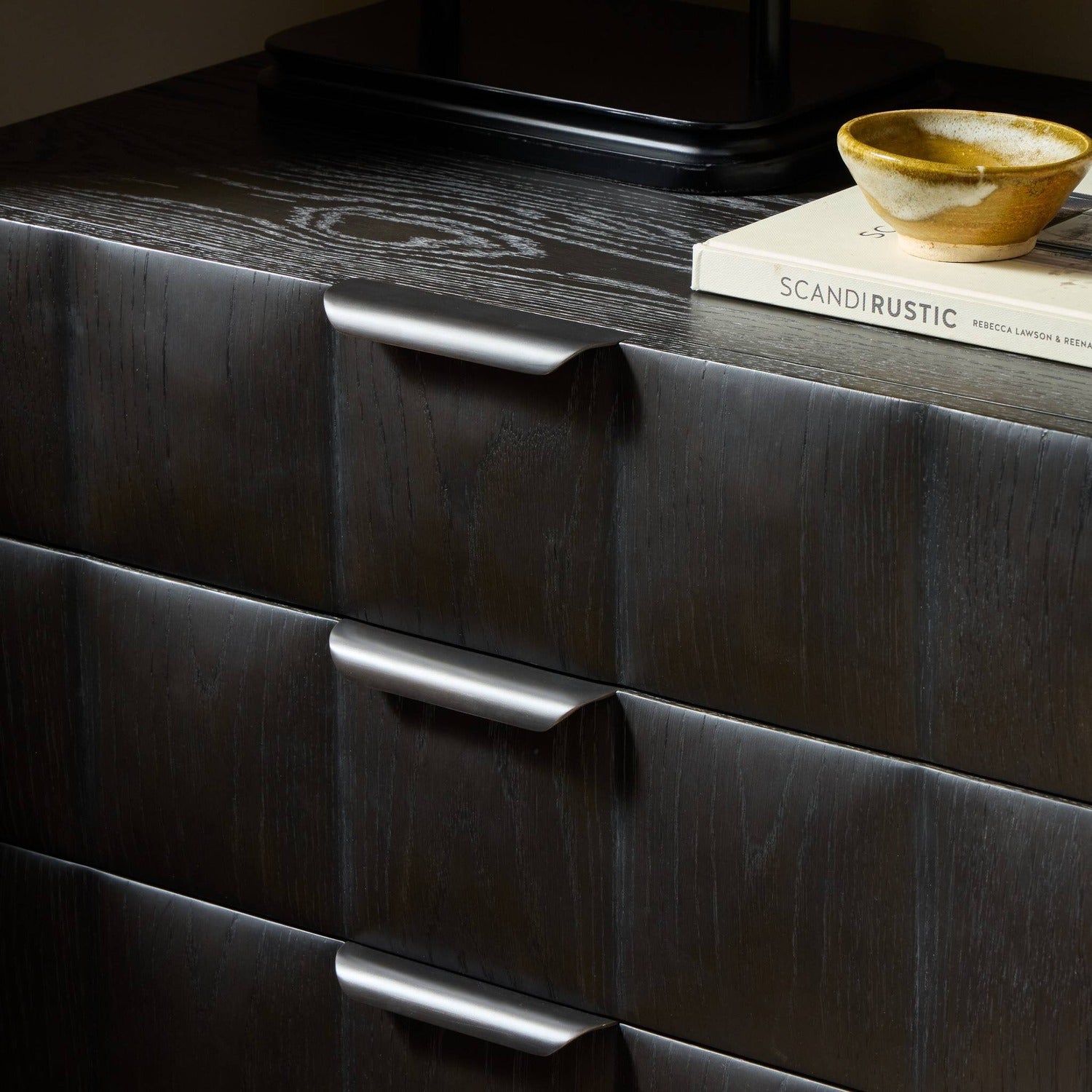 Four Hands Swell Dry Black Oak Nightstand with CNC-carved grid on pedestal base, alternate styled view