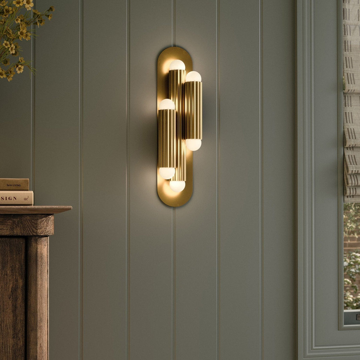 Four Hands Vesta Burnished Brass Triple Wall Sconce styled in a room setting