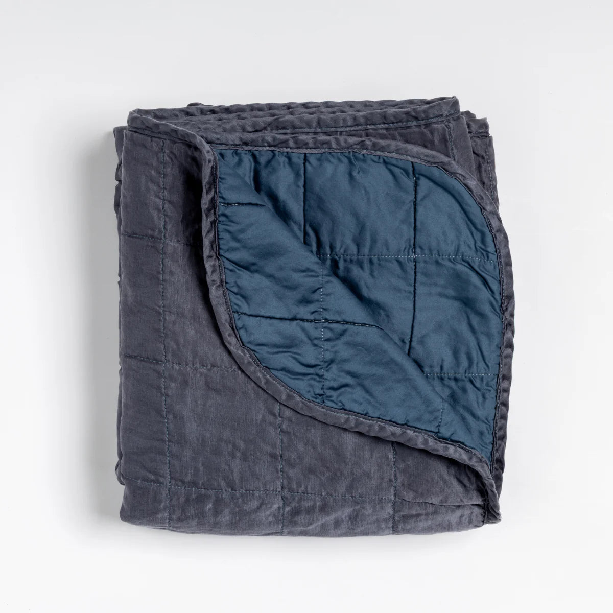 Bella Notte Sel Throw Blanket in quilted charmeuse, stacked and folded for storage