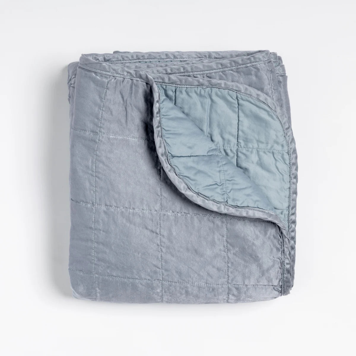 Bella Notte Sel Throw Blanket in quilted charmeuse, shown in an airy, light-filled room