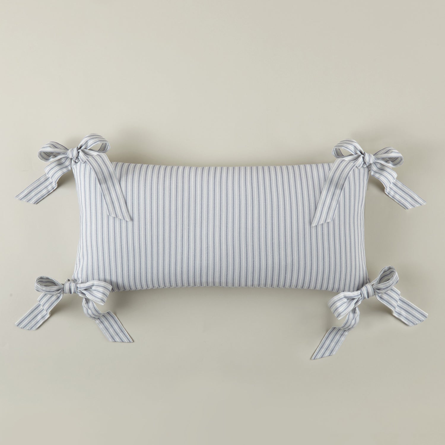 Caitlin Oblong Bow Pillow cotton flame accent pillow, layered against coordinating pillows