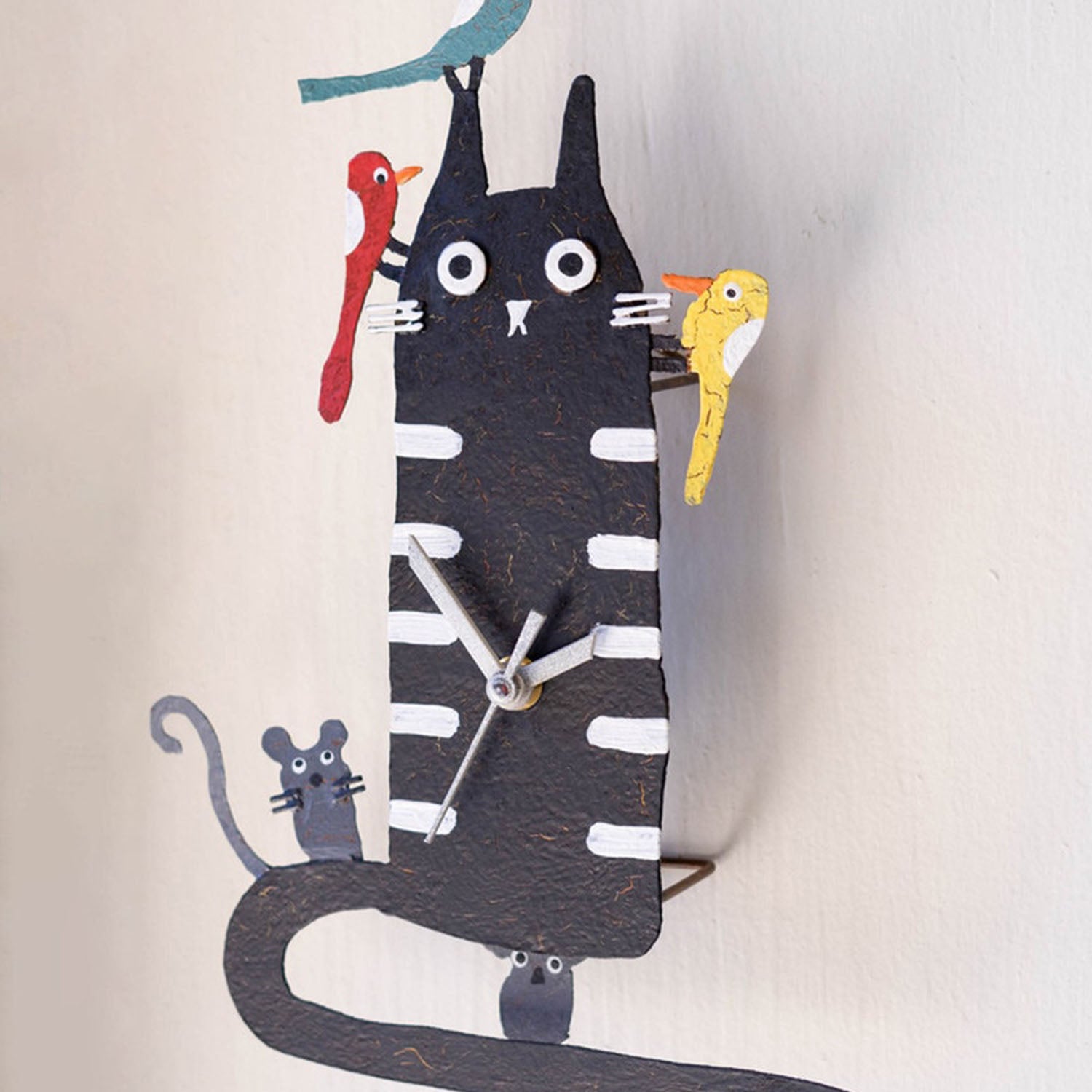 Black cat wall clock styled on a wall for scale