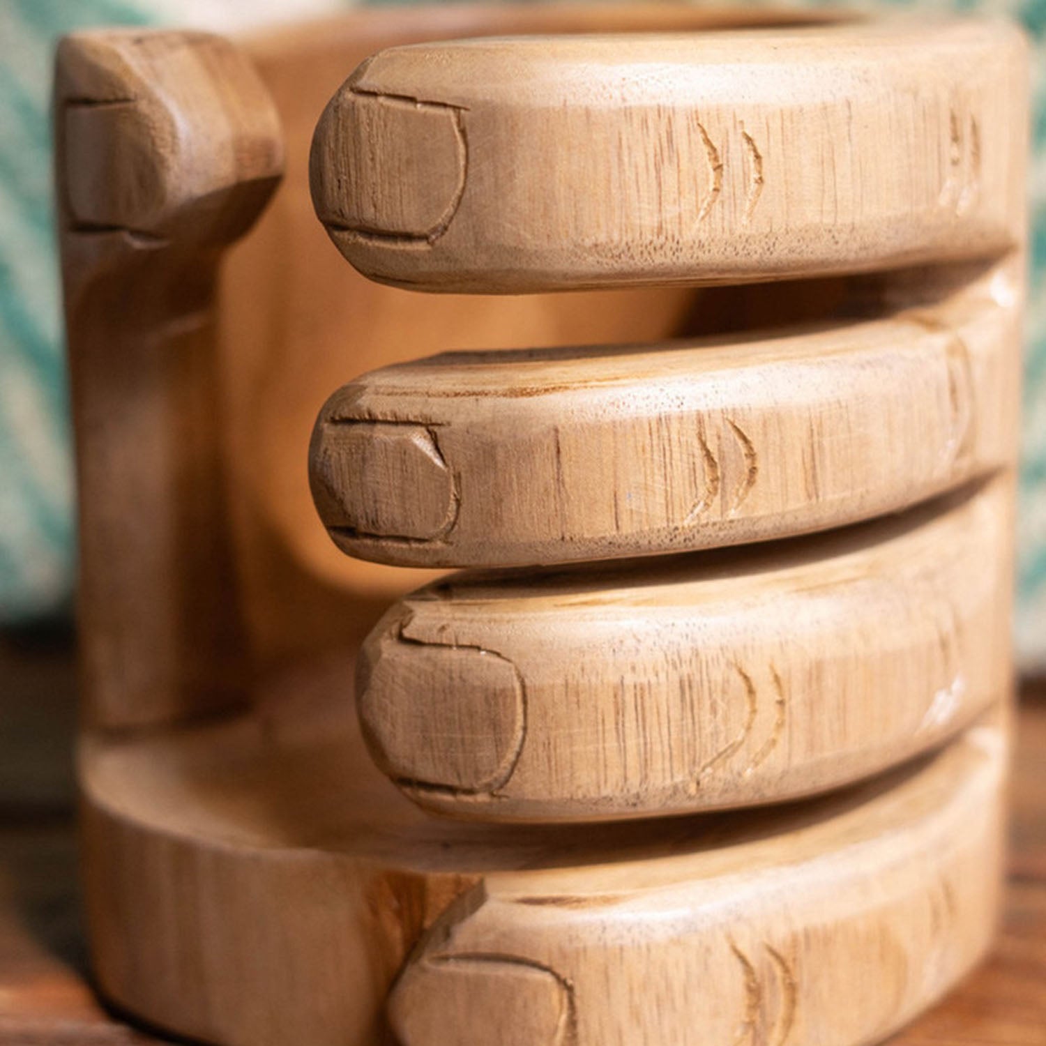 Close-up of the carved wood hand detail on the wine holder